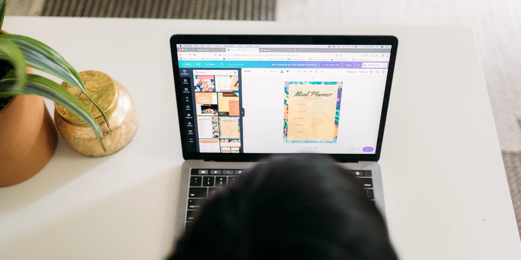 Femme créant des visuels sur un ordinateur via Canva