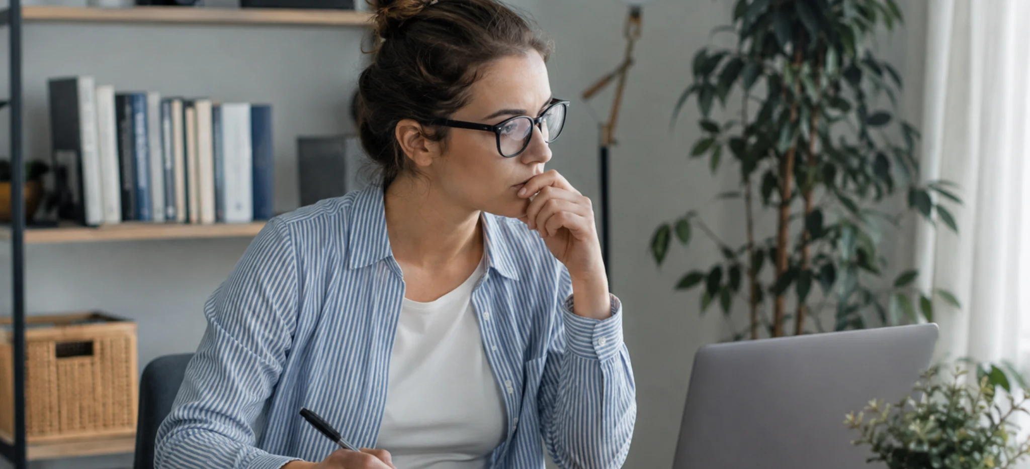 Salariée en télétravail réfléchissant à son avenir professionnel et à un bilan de compétences
